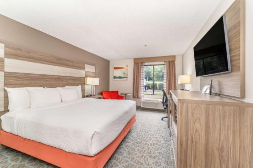 a hotel room with a bed and a flat screen tv at Best Western Kernersville in Kernersville