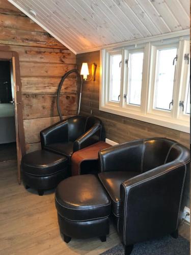 a room with leather chairs and tables and windows at Arctic Aurora View in Ytre Tomasjord