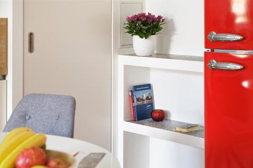 a red door with a table and a bowl of fruit at Elflein Quartier in Potsdam