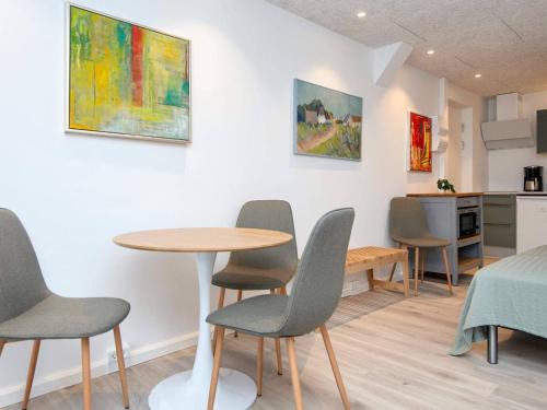a room with a table and chairs and a kitchen at 2 person holiday park home in Ringkøbing in Ringkøbing