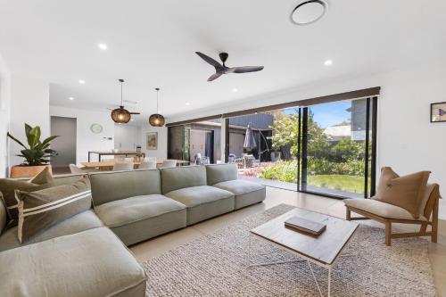 a living room with a couch and a table at Stylish Home near Noosa & Peregian, walk to Beach in Marcus Beach