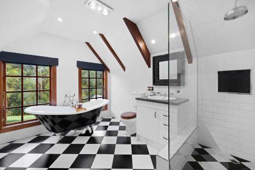 a bathroom with a black and white checkered floor at Heart of a lion in Monbulk