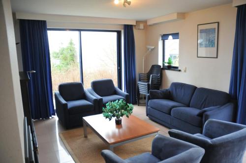 a living room with blue couches and a table at Résidence Durbuy in Durbuy