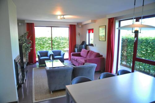 a living room with a pink couch and chairs at Résidence Durbuy in Durbuy
