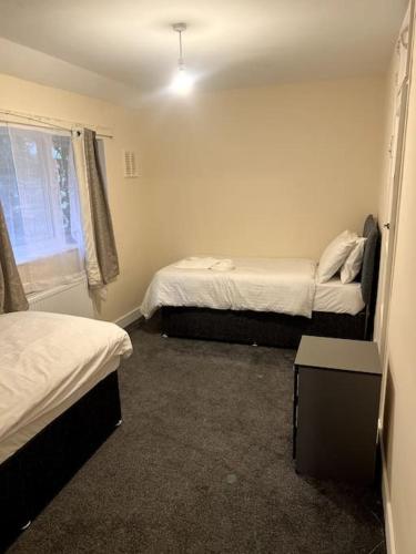 a small room with two beds and a window at Spacious City Centre Home Near Hospital & M5 in Worcester