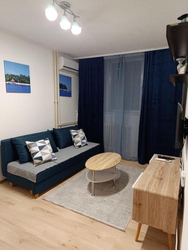 a living room with a blue couch and a table at Aurum29 in Doboj