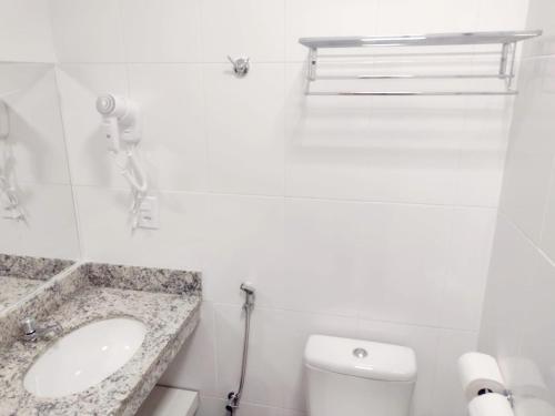 a white bathroom with a sink and a toilet at APARTAMENTO SPAZZIO DI ROMA com acesso ao ACQUA PARK SPLASH in Caldas Novas