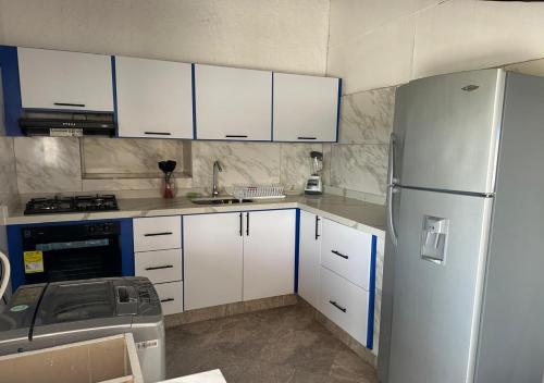 een keuken met witte kasten en een koelkast bij Apartamento Ines María in Barichara
