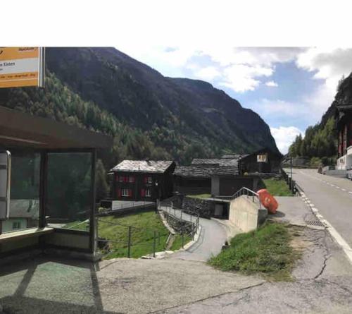 a building on the side of a road next to a mountain at Chalet Julia mit Sauna in Eisten