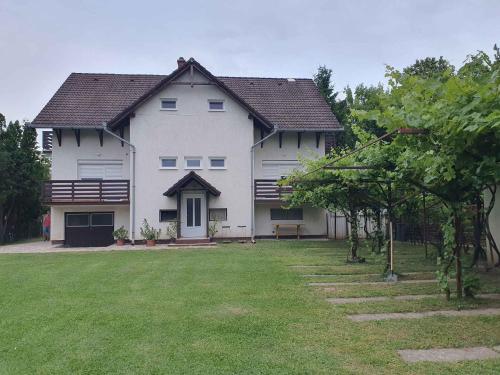ein großes weißes Haus mit einem großen Garten in der Unterkunft Apartments in Zamardi - Balaton 52987 in Zamárdi