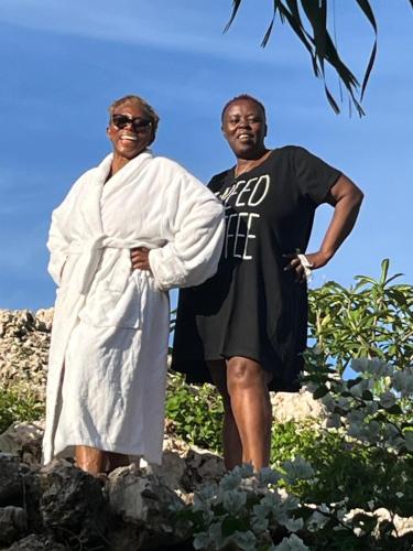 a man and a woman standing on some rocks at Eve's Rockaway Villa in Alligator Pond Village