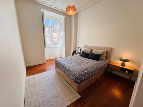 a bedroom with a bed and a large window at Augusta Luxury Apartment - near praça do comércio in Lisbon