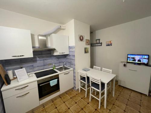 een keuken met witte kasten en een tafel met stoelen bij da Paolone in Deiva Marina