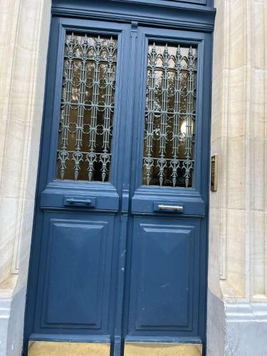 une porte bleue avec fenêtre dans un bâtiment dans l'établissement Appartement proche Montparnasse et Port Royal, à Paris