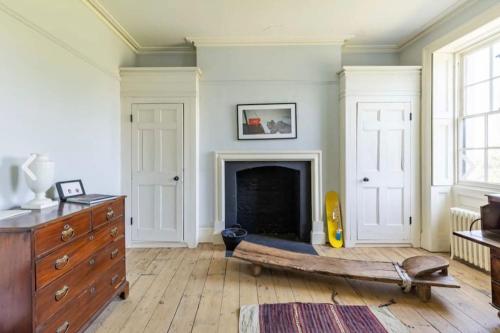 a living room with a fireplace and a dresser at Amazing Dockyard Historical Georgian House in Kent
