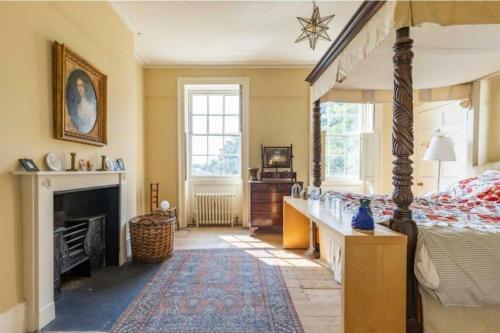 a bedroom with a bed and a fireplace at Amazing Dockyard Historical Georgian House in Kent