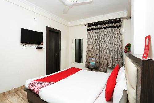 a bedroom with a large bed and a television at Hotel O Relax in Gwalior