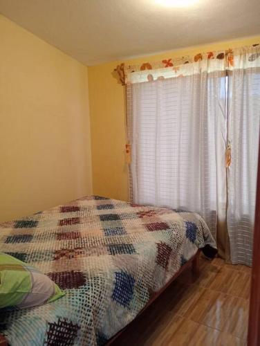 a bedroom with a bed and a window with curtains at Casa céntrica in Chignahuapan