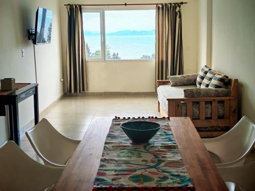 Sala de estar con mesa y sillas y vistas al océano en De cara al lago Bariloche U4, en San Carlos de Bariloche