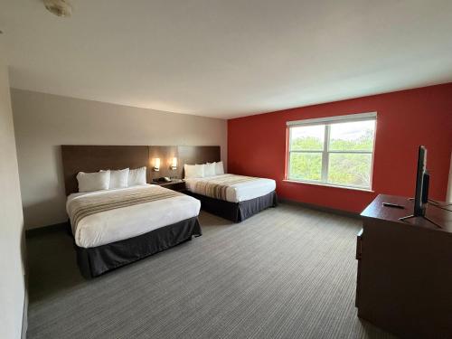 a hotel room with two beds and a window at Country Inn & Suites by Radisson, Harlingen, TX in Harlingen