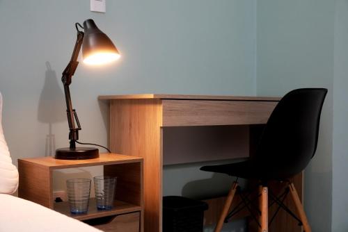 a desk with a black chair and a lamp at Ideal para trabajar y descansar in Cali