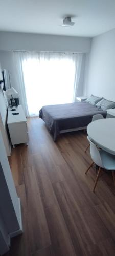 マル・デル・プラタにあるAmplio y luminoso monoambiente a 100 mts del marのベッドと大きな窓のある寝室