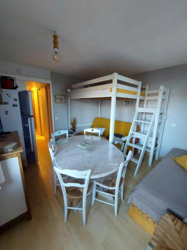 - une salle à manger avec une table et des lits superposés dans l'établissement appartement aux coches 6 personnes 1 chambre 23m2 8 couchages, à Les Coches
