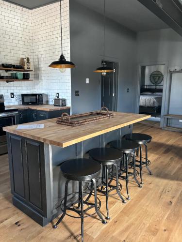 a kitchen with a large wooden counter with stools at the old soda factory in Mount Carmel