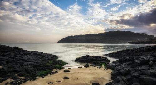 a view of a beach with rocks and the ocean at Ebenezer Hotel in Jeju