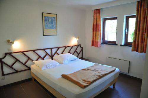 a bedroom with a bed with white sheets and pillows at Résidence Durbuy in Durbuy
