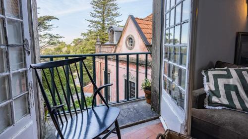 an open door to a balcony with a chair and a church at Giant Smart Room, Hot tub, PS5, in Historical Sintra Center inside 17th century Palace - Sintra WOW in Sintra