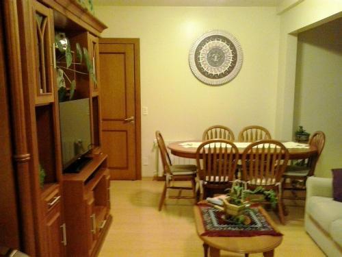 格拉馬杜的住宿－Apartamento Solar do Centro - Gramado RS，客厅设有餐桌和椅子