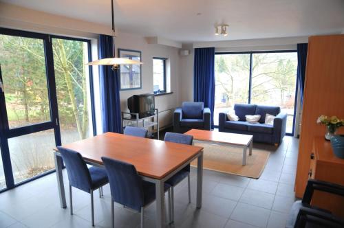 a living room with a table and chairs and a couch at Résidence Durbuy in Durbuy