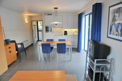 a kitchen and dining room with a table and blue chairs at Résidence Durbuy in Durbuy