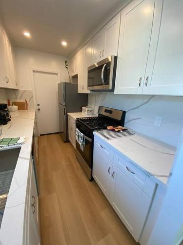 a kitchen with white cabinets and a stove top oven at 4 Stanford! Furnished Apartment, Gated Parking, Laundry in East Palo Alto