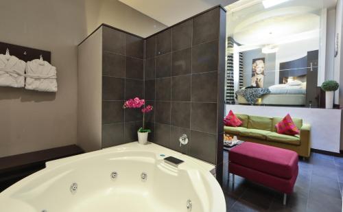 a bathroom with a bath tub and a bedroom at Best Western Cinemusic Hotel in Rome
