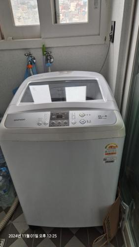 a washing machine in a room with a window at Busan Suwol in Busan