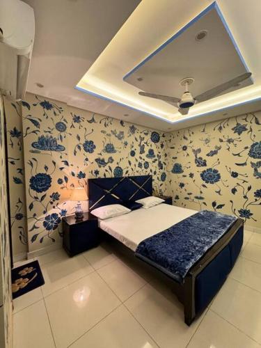 a bedroom with a bed with blue flowers on the wall at 1BR Indigo Haven Retreat with City Views in Rāmkot
