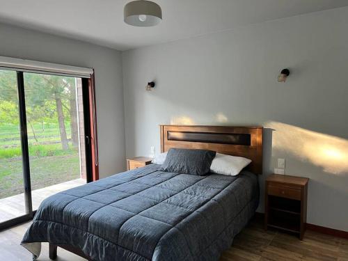 a bedroom with a bed and a large window at Cabaña de campo pequeña in Los Ángeles