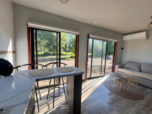 a kitchen and living room with a table and chairs at Cabaña de campo pequeña in Los Ángeles