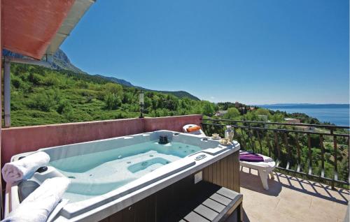 a hot tub on a balcony with a view of the ocean at Holiday Home Gornji Tucepi-Srida Sela Bb Ii in Tučepi