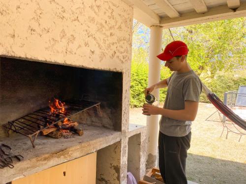 a young man is standing in front of a fireplace at El Solar Casas de Campo 3 in Valle Grande