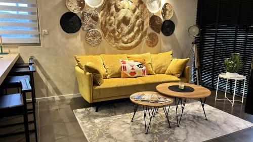 - un salon avec un canapé jaune et 2 tables dans l'établissement SUNRISE & SUNSET PALM BEACH CROISETTE, à Cannes