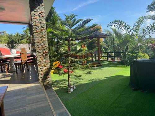 a garden with a christmas tree next to a house at Phuenics de galera in Puerto Galera