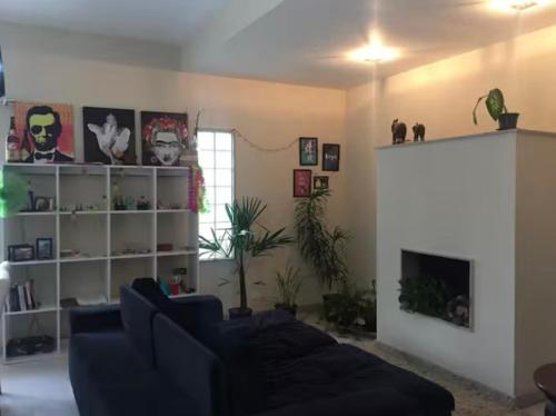 un salon avec un canapé et une étagère dans l'établissement Casa ao lado Pedreira Paulo Leminski confortável 15 min centro da cidade e centro histórico pontos turísticos shows eventos fácil acesso com estacionamento, à Curitiba