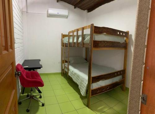 a room with two bunk beds and a desk and a chair at Apartamento Estancia Tropical in Pucallpa