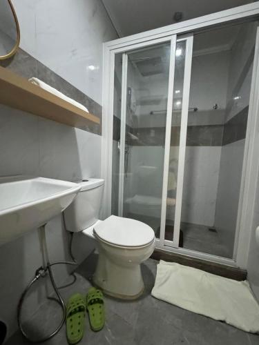 a bathroom with a toilet and a shower and a sink at Phuenics de galera in Puerto Galera