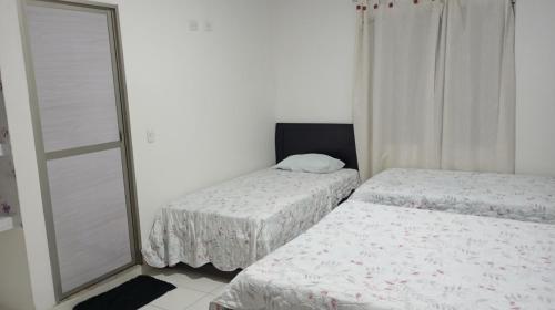 a bedroom with two beds and a mirror at Cabaña Rochy in Coveñas