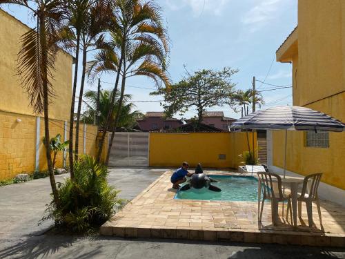 a man sitting in a pool with a ball in it at Pousada Amarela Beach in Itanhaém