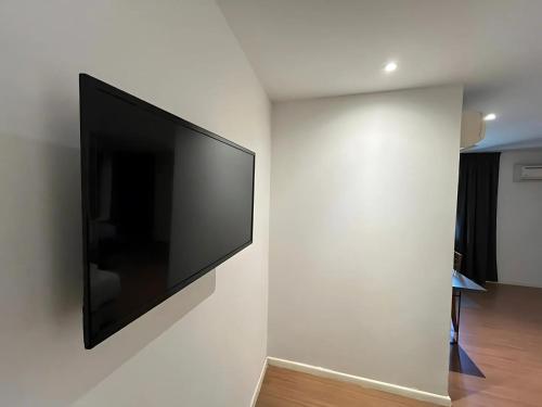 a flat screen tv hanging on a white wall at Sky Hotel Cheras Maluri in Kuala Lumpur
